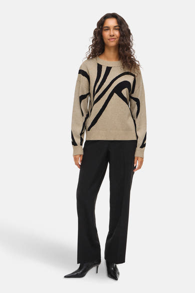 Beige ronde hals trui van VILA, met zwart grafisch patroon en gedragen met een zwarte broek.