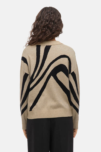 Pull à col rond beige de VILA, avec motif graphique noir sur le dos.
