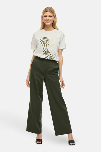 T-shirt à manches courtes blanc de VILA®, imprimé avec des feuilles et un soleil, porté avec un pantalon vert olive.
