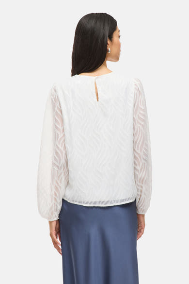 Witte blouse met lange mouwen van VILA®, golvend patroon en doorschijnende mouwen, gedragen met een blauwe rok.