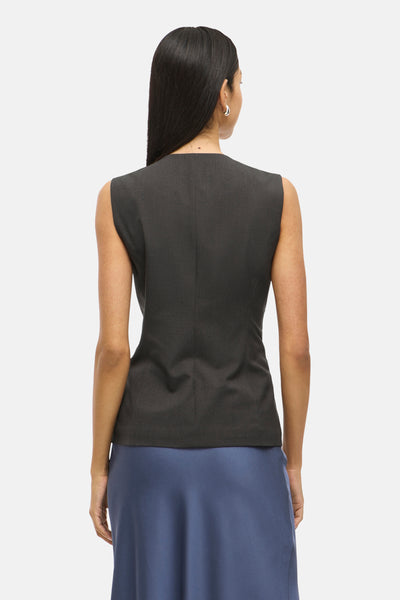 Blazer gris, par VILA, avec une coupe sans manches et une jupe bleu pétrole.