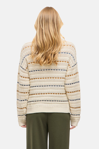 Pull à col rond beige de VILA®, avec motifs rayés et ajourés, porté avec un pantalon vert.
