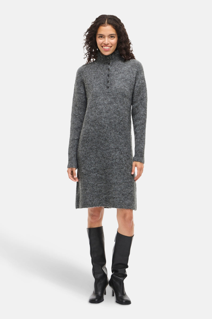 Robe grise à manches longues par VILA, portée avec des bottes hautes en cuir noir à talons.
