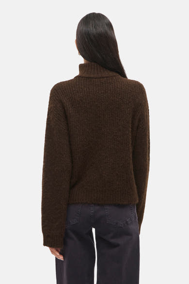 Bruine trui van VILA met coltrui en gebreide textuur, gedragen met een donkere broek.