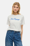 Wit T-shirt met korte mouwen van VILA®, met de blauwe tekst "Ciao Ragazzi", gedragen met een spijkerbroek en bruine schoenen.