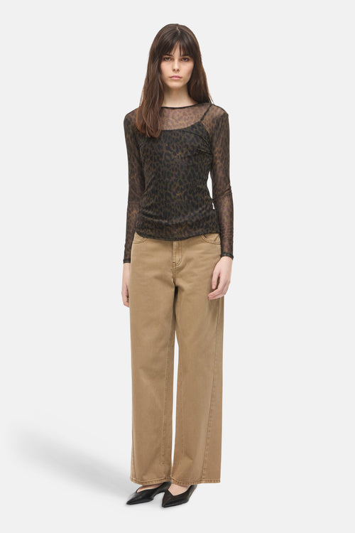 Multicolored long-sleeve sheer top with leopard print, worn with beige wide-leg pants and black pointed-toe flats, front view.