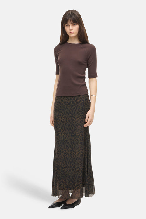 Multicolored leopard-print formal skirt with sheer hem, worn with brown top and black flats, front view