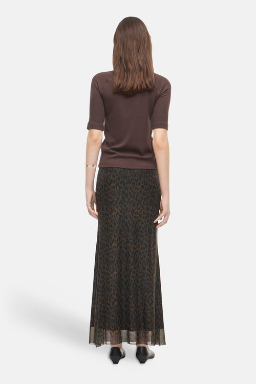 Multicolored leopard-print formal skirt with sheer hem, back view, worn with brown top and black shoes