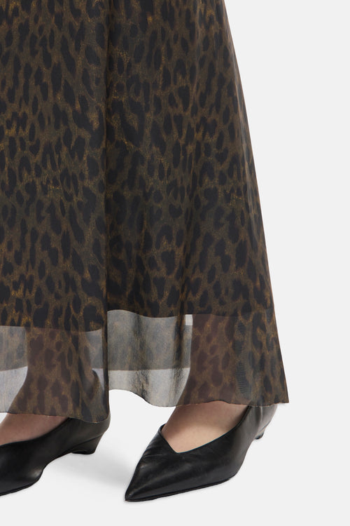 Multicolored leopard-print formal skirt with sheer overlay hem, worn with black pointed-toe heels, side view close-up