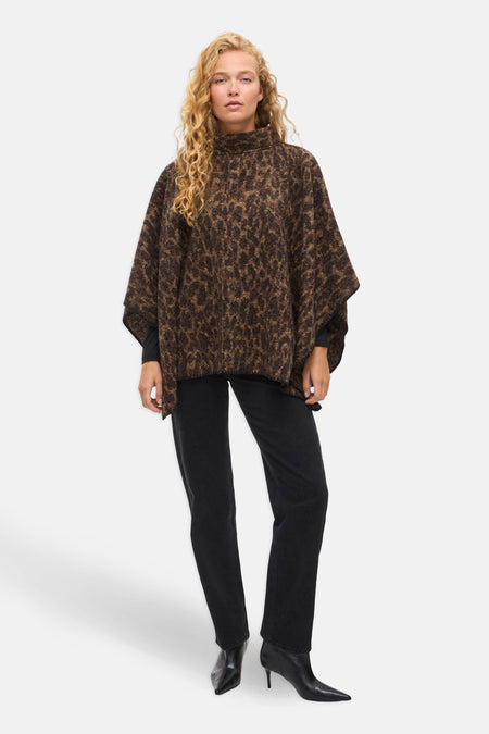 Bruine poncho met luipaardprint van Vila, gedragen met een zwarte jeans en puntige enkellaarsjes met hak.