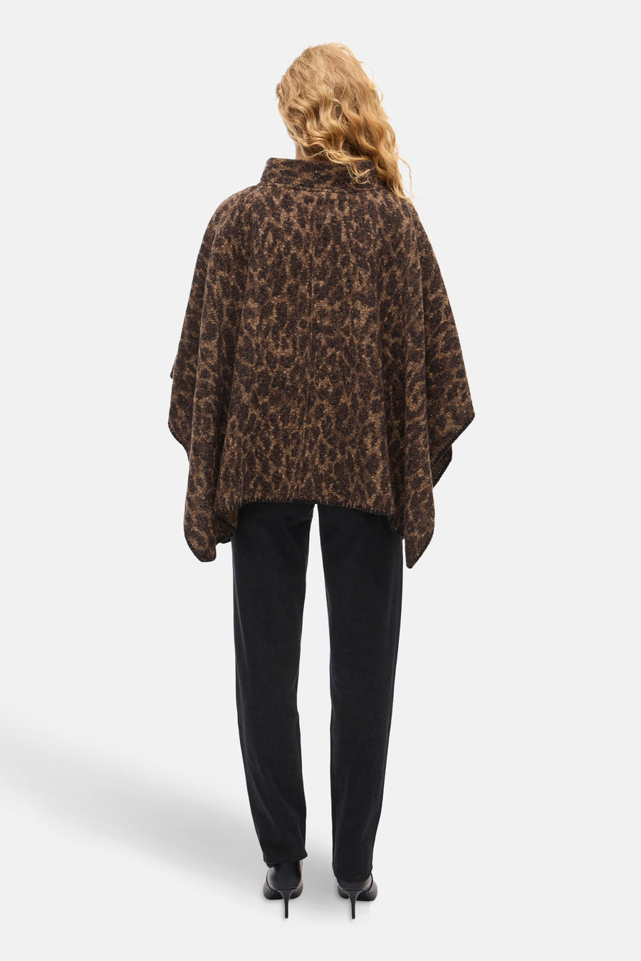 Poncho marron à motif léopard de VILA, porté avec un pantalon noir et des talons aiguilles noirs, vue de dos.
