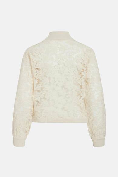 Beige coltrui van VILA, met bloemenpatroon van kant op een licht doorschijnende achtergrond.