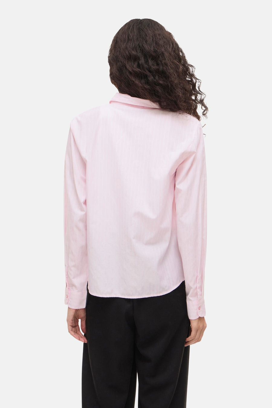 Chemise à manches longues rose à rayures, par VILA, portée avec un pantalon noir.