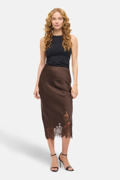 Jupe 3/4 brune de VILA®, avec bordure en dentelle florale et portée avec un haut noir uni.
