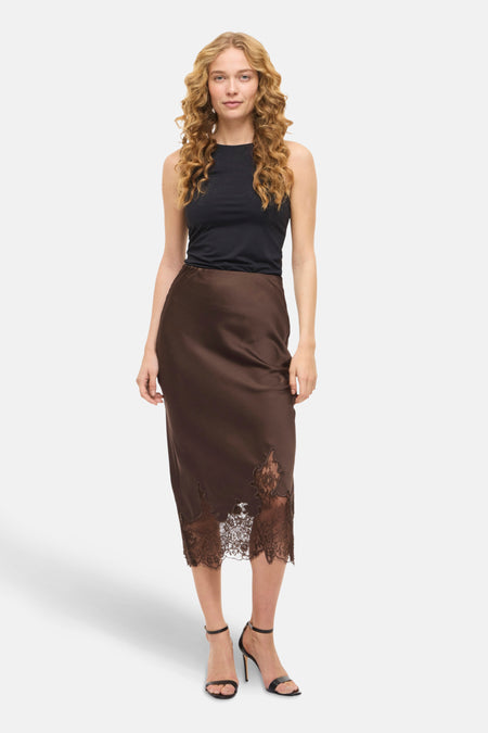 Jupe 3/4 brune de VILA®, avec bordure en dentelle florale et portée avec un haut noir uni.
