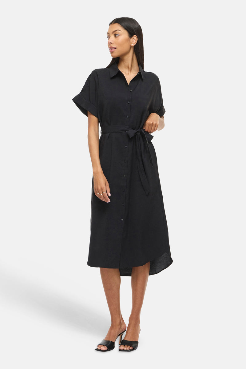 Zwarte jurk met knopen van VILA, met een strikceintuur, korte mouwen met omslag en een asymmetrische midi-pasvorm.