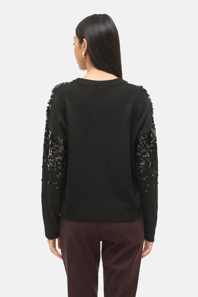 Zwarte rondehals trui van VILA®, versierd met decoratieve pailletten op de mouwen, gedragen met een bruine broek.