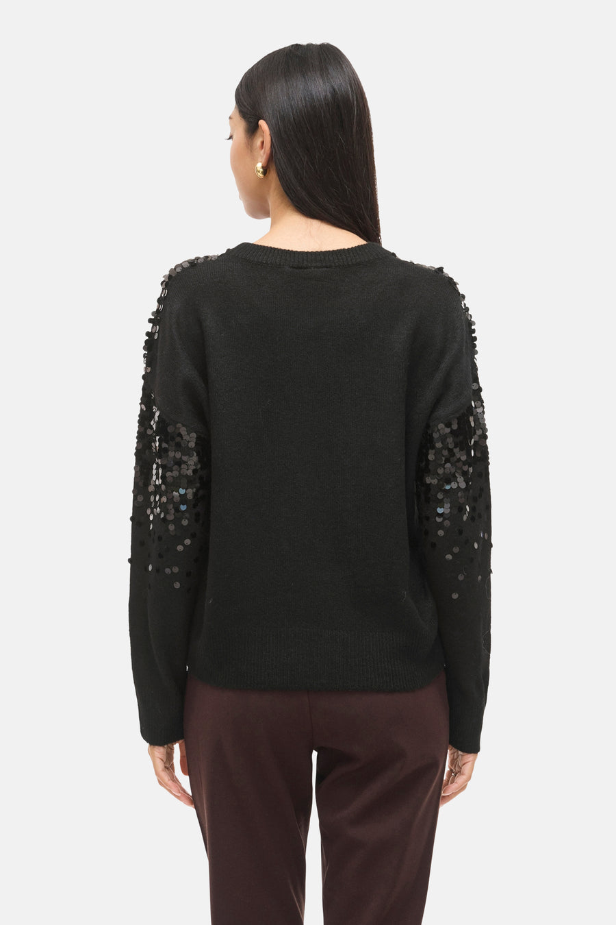Zwarte rondehals trui van VILA®, versierd met decoratieve pailletten op de mouwen, gedragen met een bruine broek.