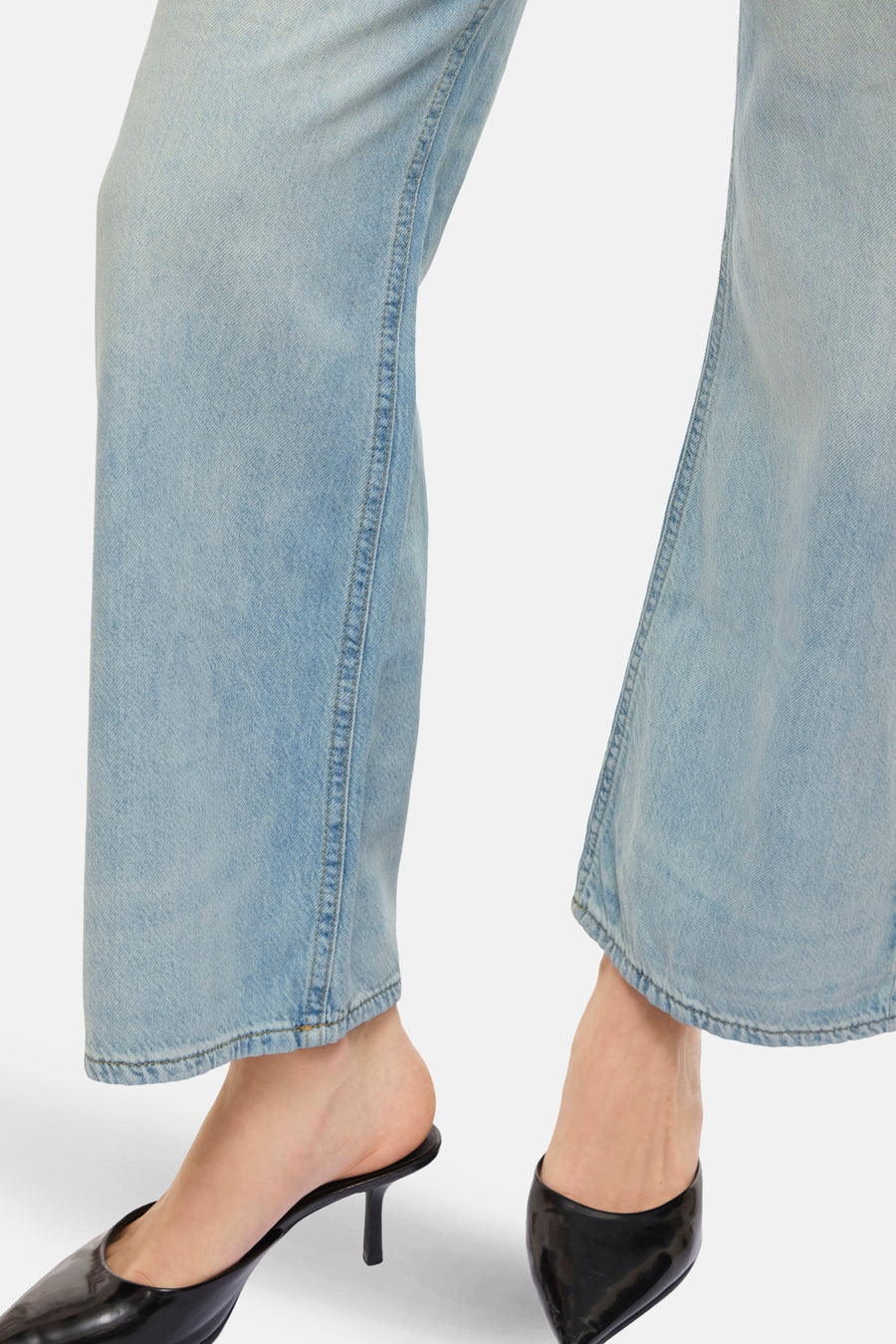Wijde spijkerbroek in lichtblauw denim van VILA, met zoom over glanzende zwarte schoenen.