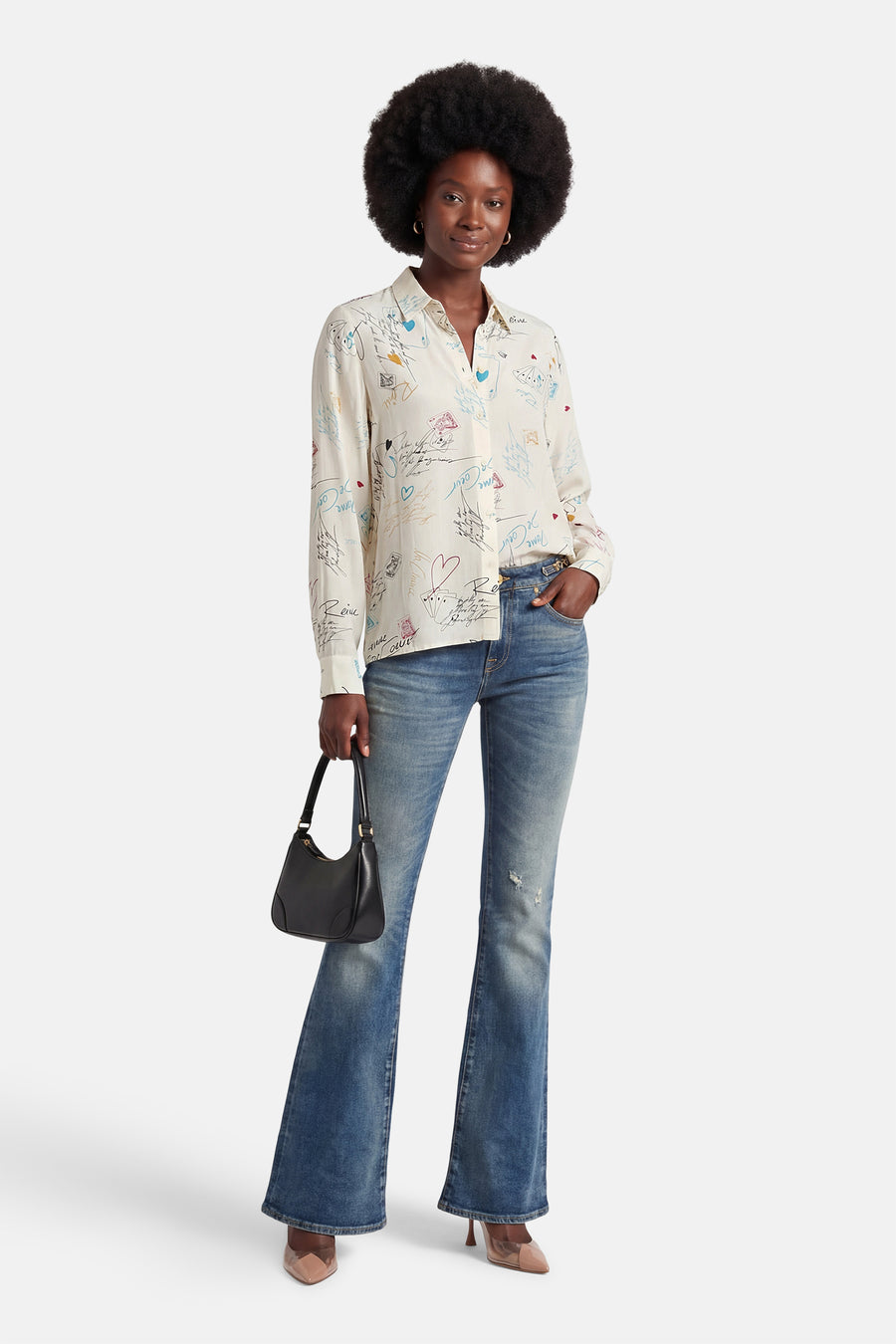 Chemise à manches longues multicolore de VILA, avec des motifs imprimés, portée avec un jean évasé et des escarpins.
