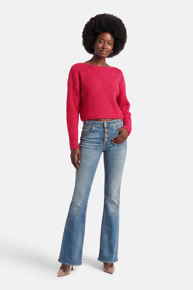 Roze rondehals trui van VILA®, gedragen met een high-waist flared jeans en doorschijnende pumps.