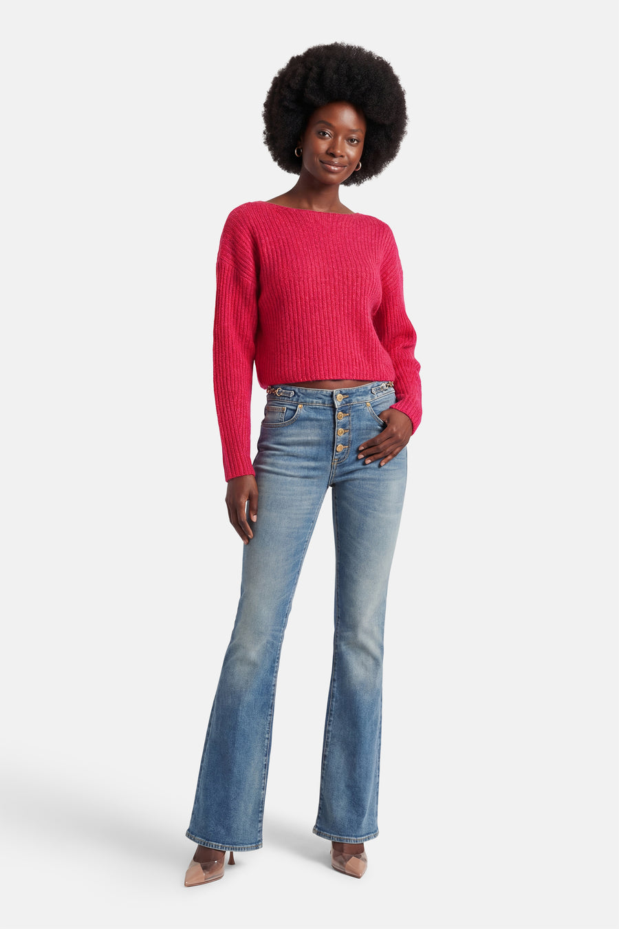 Roze rondehals trui van VILA®, gedragen met een high-waist flared jeans en doorschijnende pumps.