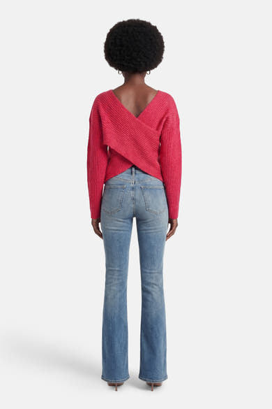 Pull rose à col rond de VILA®, porté avec un jean taille haute évasé.