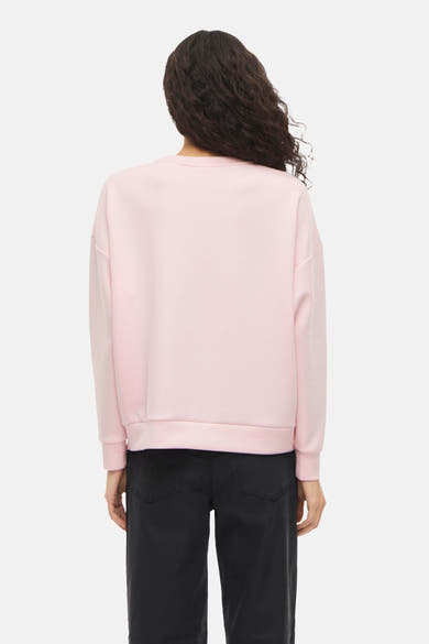 Roze sweatshirt van VILA, met lange mouwen en geribbelde zoom, gedragen met een zwarte high-waist broek.