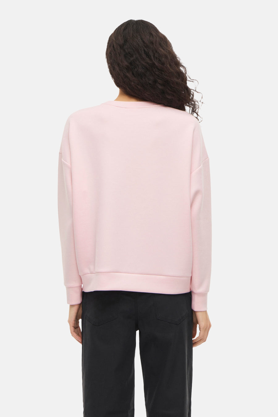 Roze sweatshirt van VILA, met lange mouwen en geribbelde zoom, gedragen met een zwarte high-waist broek.