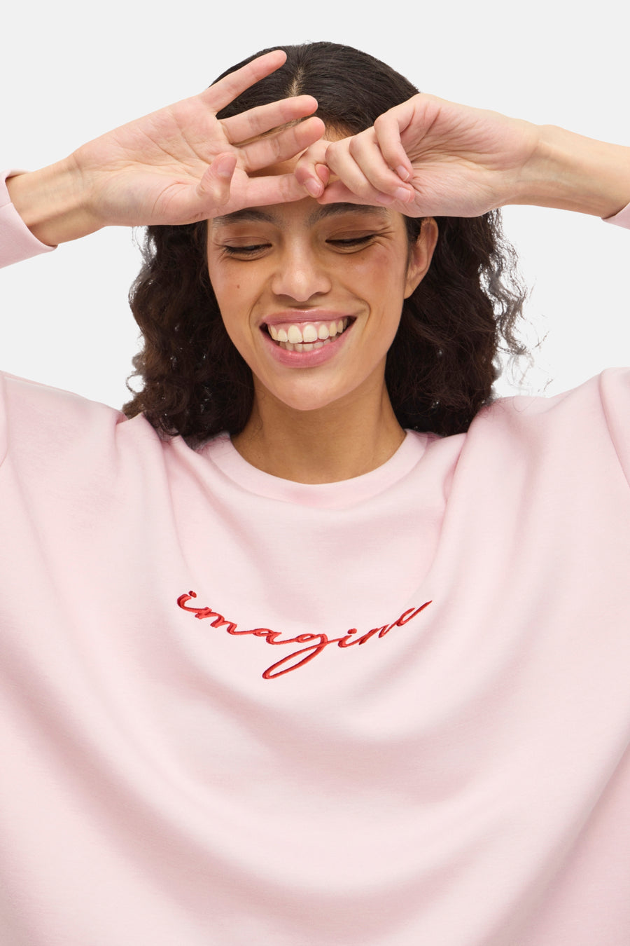 Zweetshirt van VILA® met de tekst 'imagine' in rood geborduurd op de voorkant, gedragen door een lachende mannequin.