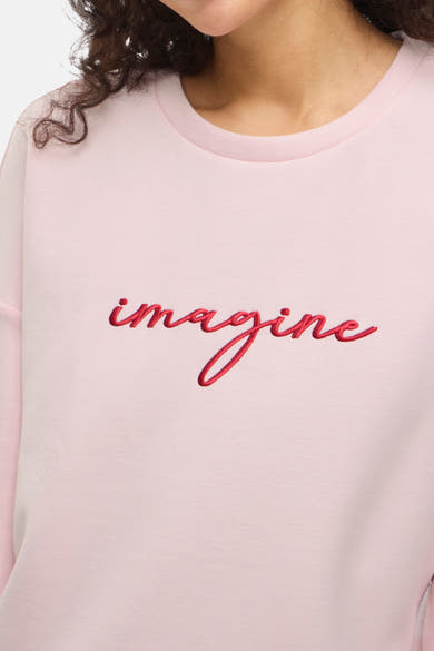Roze sweatshirt van VILA met het woord "imagine" in rood geborduurd, ronde hals en lange mouwen, vooraanzicht.
