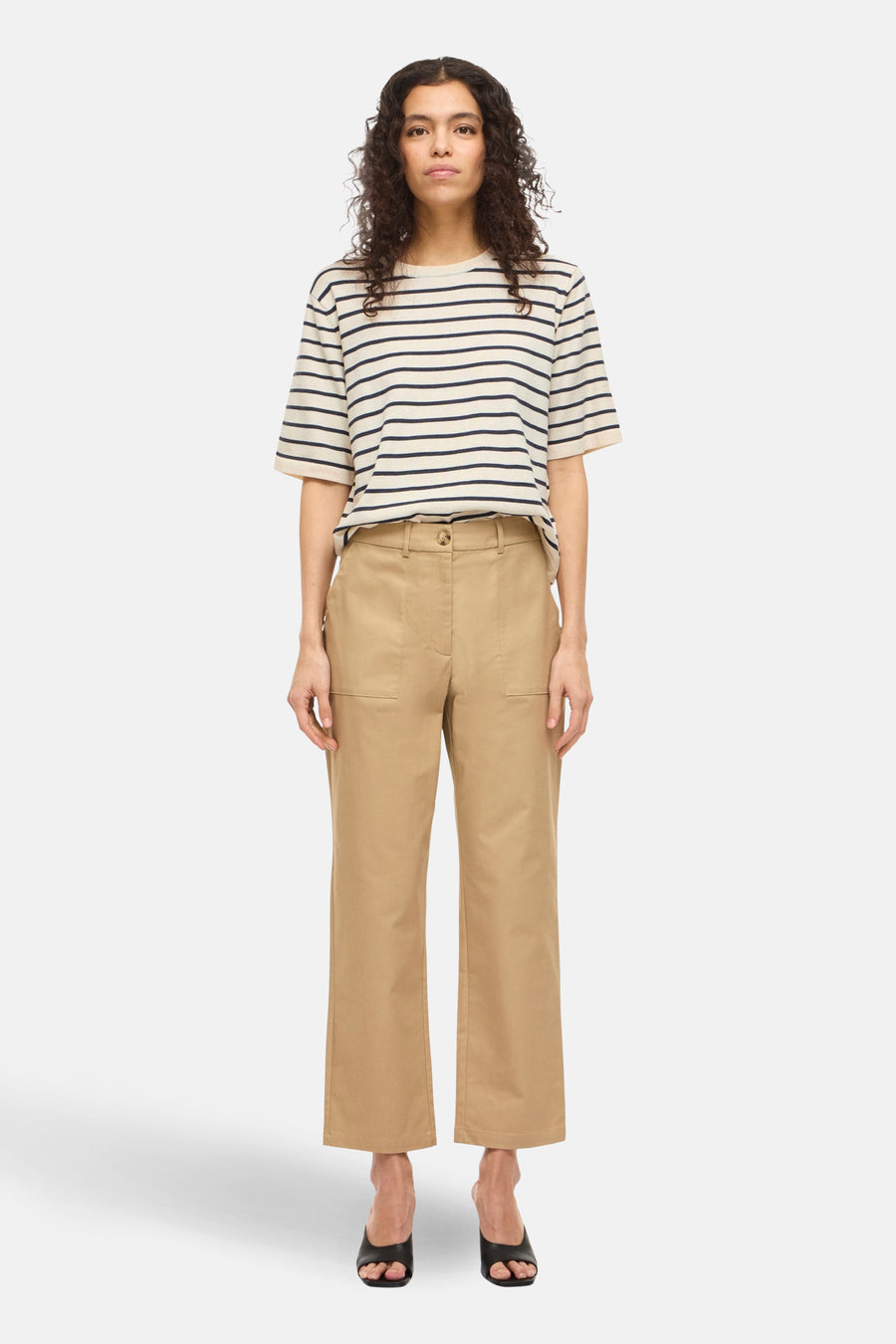 Beige T-shirt met korte mouwen en marineblauwe strepen van VILA®, gedragen met een beige broek en zwarte hakken.