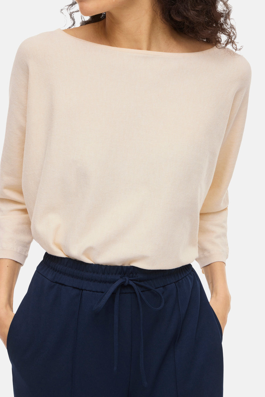 Pull à col rond beige de VILA, manches trois-quarts et coupe décontractée, porté avec un pantalon bleu marine.
