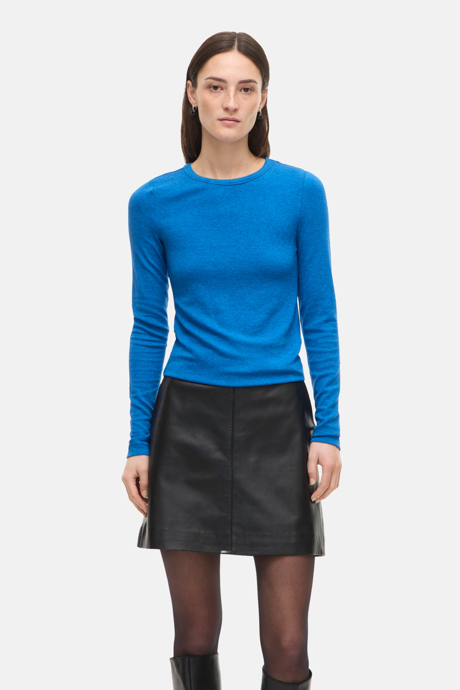 T-shirt bleu à manches longues de ROUGE EDIT, porté avec une jupe noire courte et des collants opaques.
