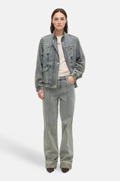 Jean large en denim bleu clair de ROUGE EDIT, porté avec une veste en jean assortie et un t-shirt écru.