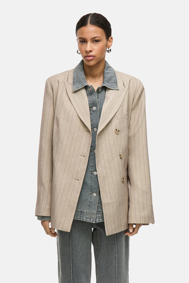 Blazer beige à rayures de ROUGE EDIT, porté avec une chemise et un pantalon en denim gris.
