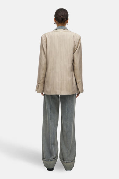 Beige blazer met rode strepen van ROUGE EDIT, gedragen met een blauw spijkerblouse en een wijde broek.