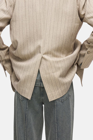 Beige blazer met fijne strepen van ROUGE EDIT, met split aan de achterkant en gedragen met een jeans.