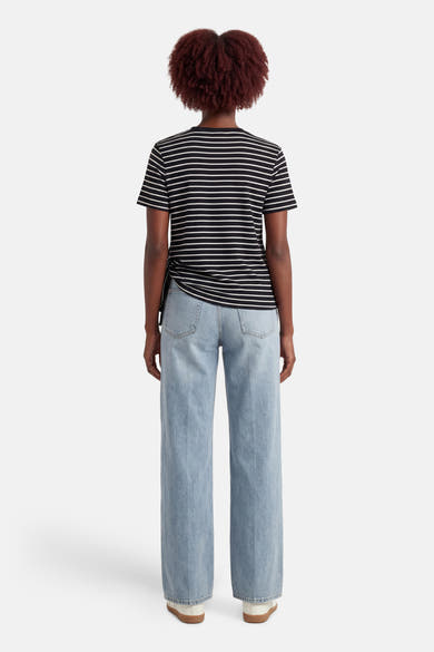 Zwart gestreept T-shirt met korte mouwen van VILA®, gedragen met een lichtblauwe wijde jeans.