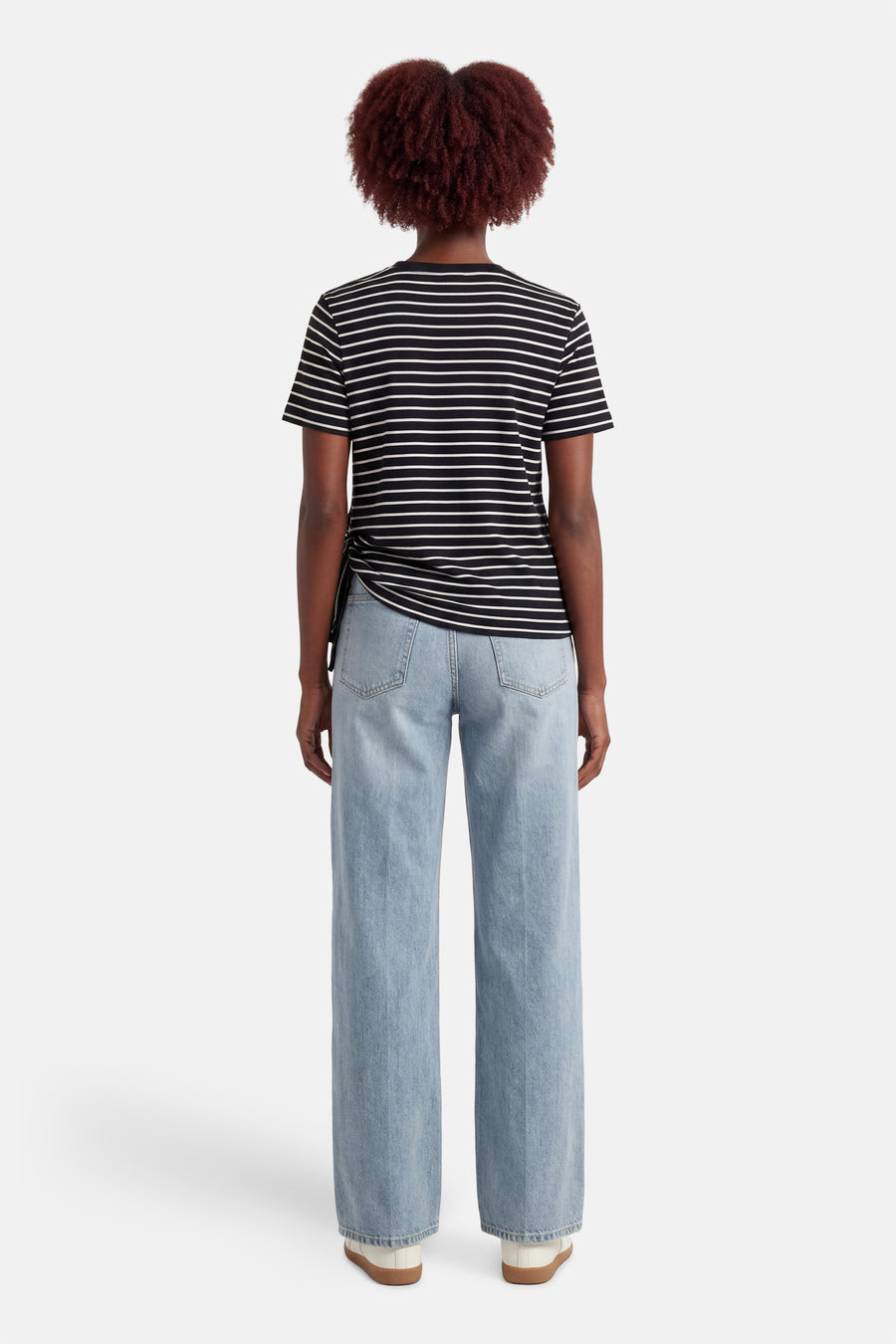 Zwart gestreept T-shirt met korte mouwen van VILA®, gedragen met een lichtblauwe wijde jeans.