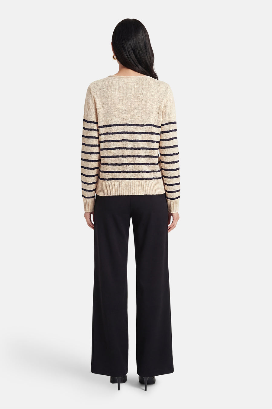 Pull à col en V multicolore de VILA®, rayé et porté avec un pantalon noir ample.