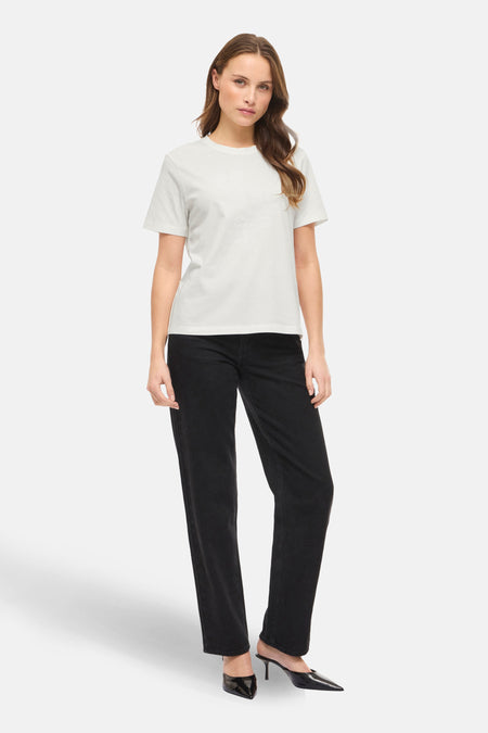 T-shirt blanc à manches courtes de VILA®, porté avec un jean noir et des chaussures à talons noirs.