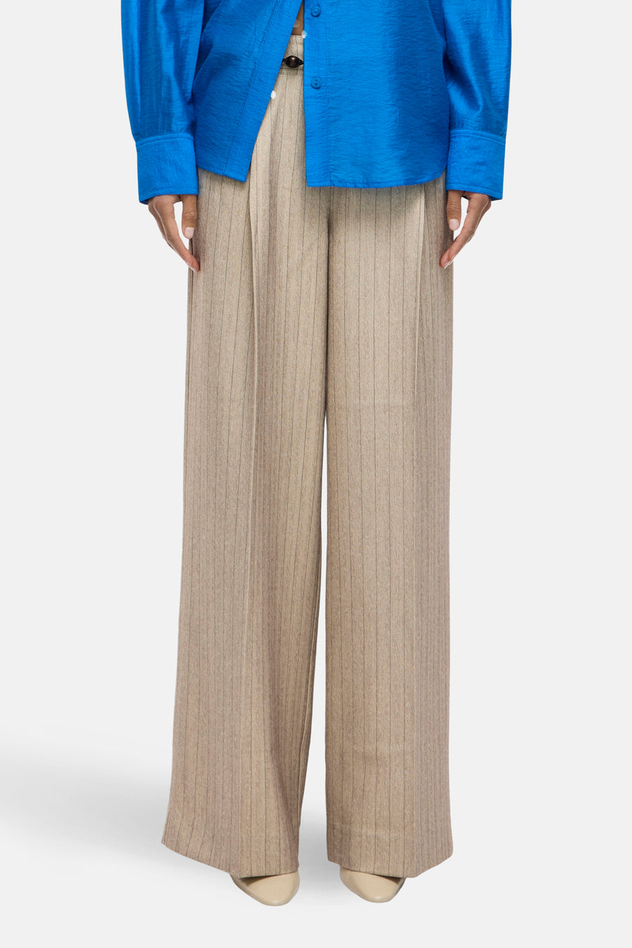 Pantalon de costume beige à rayures fines, par ROUGE EDIT, avec une coupe ample et des plis structurés.