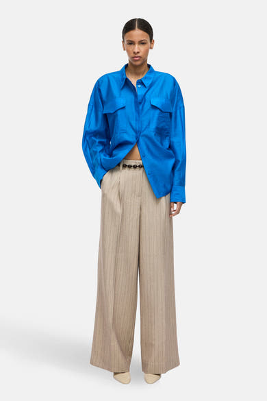 Pantalon de costume beige à rayures, de ROUGE EDIT, avec une ceinture marron à perles.