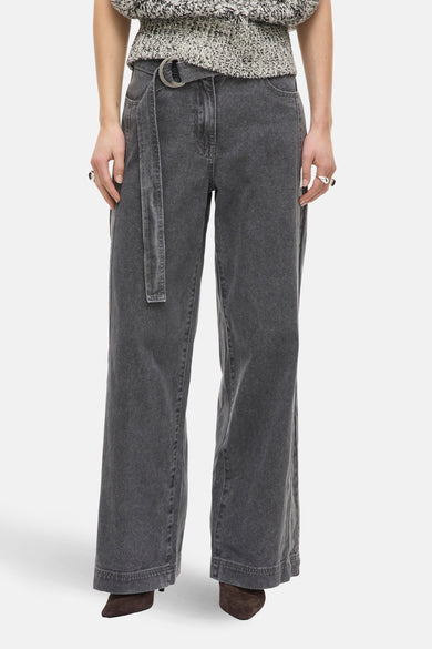 Jean gris à jambes larges de ROUGE EDIT, avec ceinture assortie et anneau en métal.