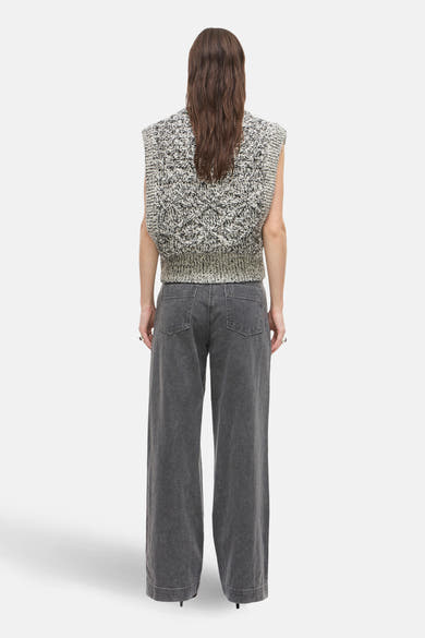 Autre jeans gris de ROUGE EDIT, porté avec un pull sans manches en maille à motifs.