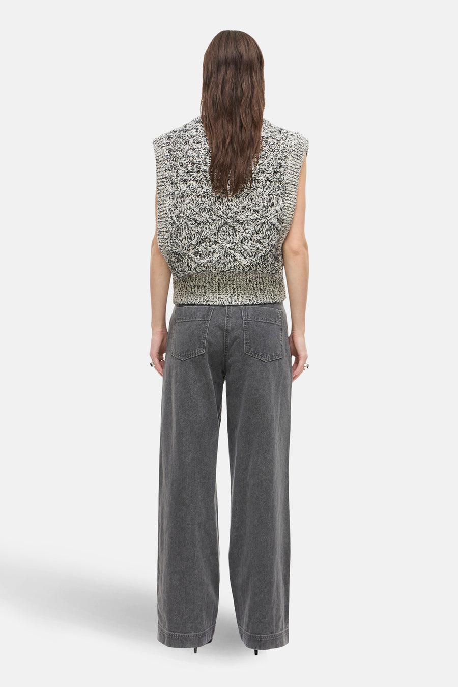 Autre jeans gris de ROUGE EDIT, porté avec un pull sans manches en maille à motifs.