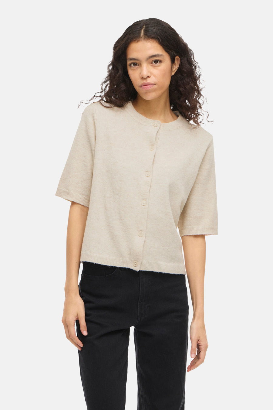 Beige gilet van VILA, gedragen met een zwarte jeans en bruine pumps.