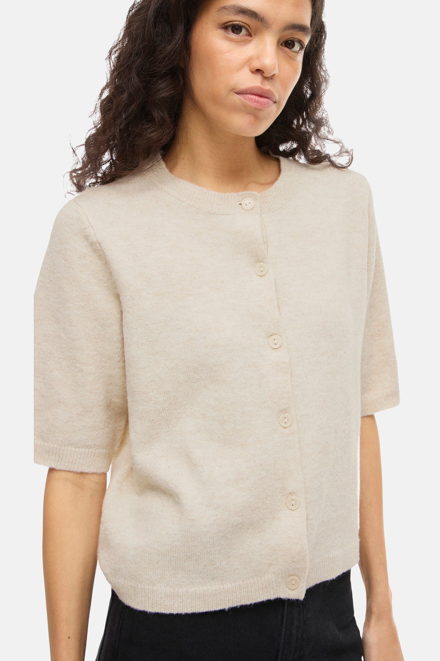 Beige vest van VILA®, met korte mouwen en knopen, gedragen met een zwarte broek.