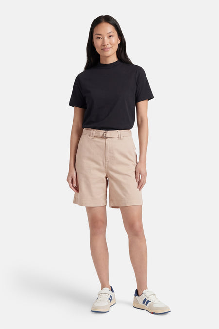 Korte beige short van VILA met bijpassende D-ring gesp riem, gedragen met een zwart T-shirt en sneakers.